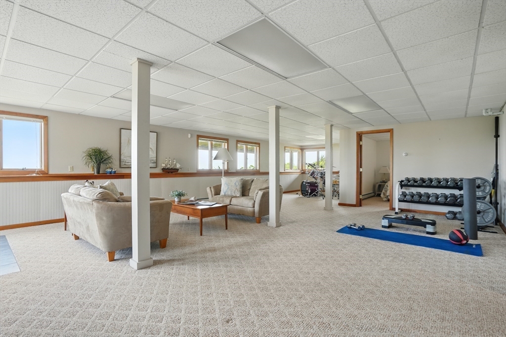 45 Phillips Road Bourne, MA 02562 - Photo 35 of 42 a living room with furniture and a dining table with projector the kitchen