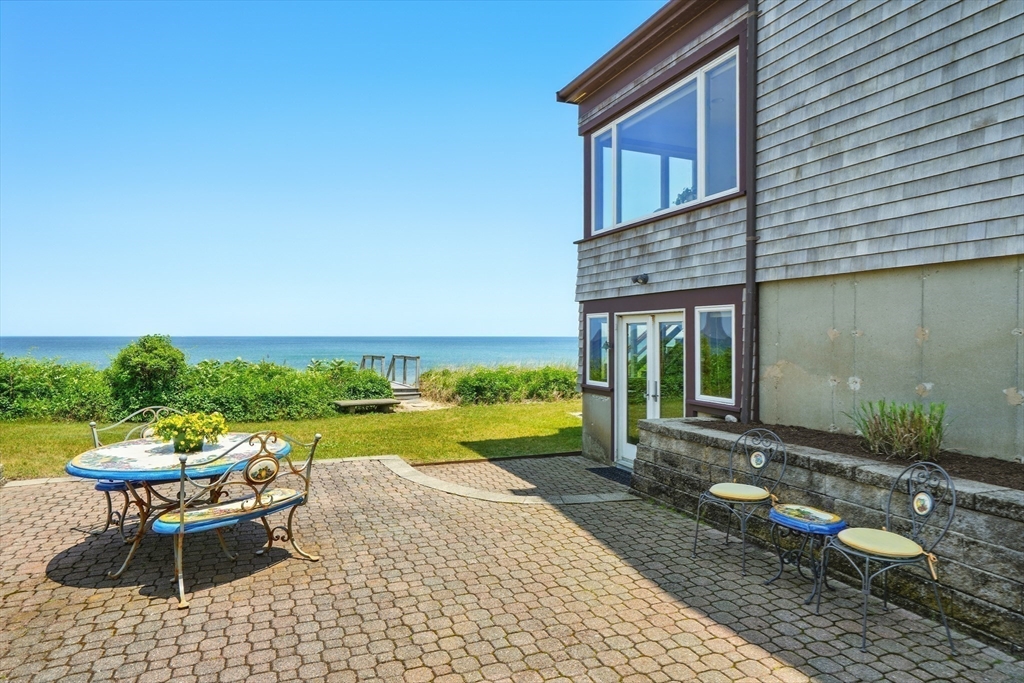 45 Phillips Road Bourne, MA 02562 - Photo 37 of 42 a front view of a house with a yard table and chairs