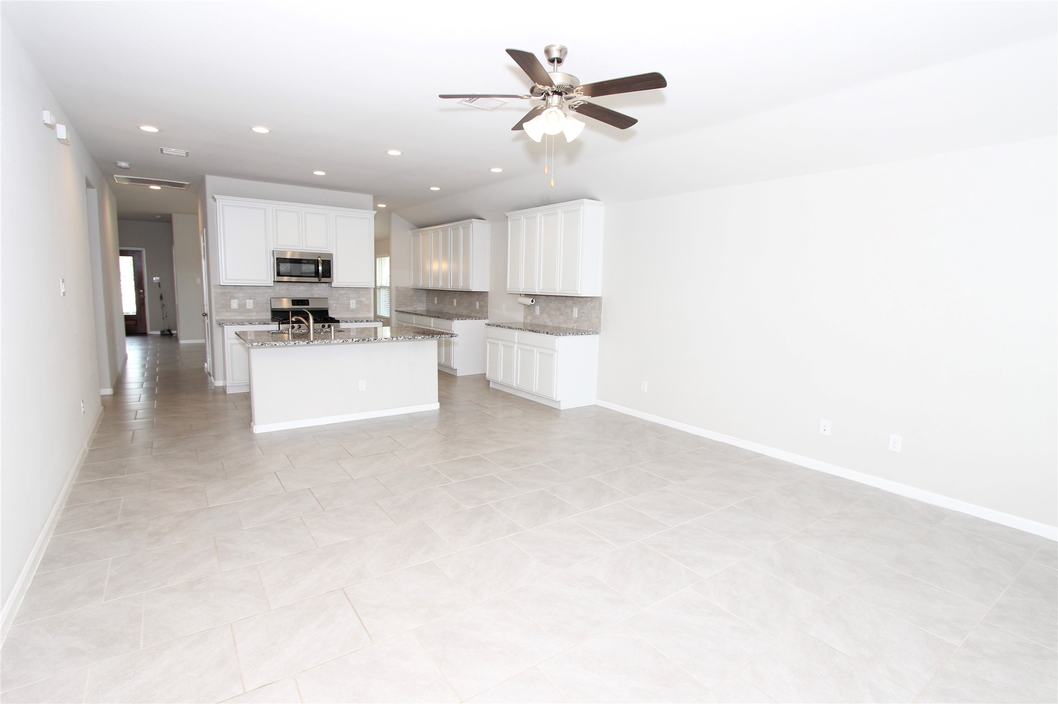 1303 Keaton Court Rosenberg, TX 77469 - Photo 7 of 22 a view of a kitchen with kitchen island a sink stainless steel appliances and cabinets