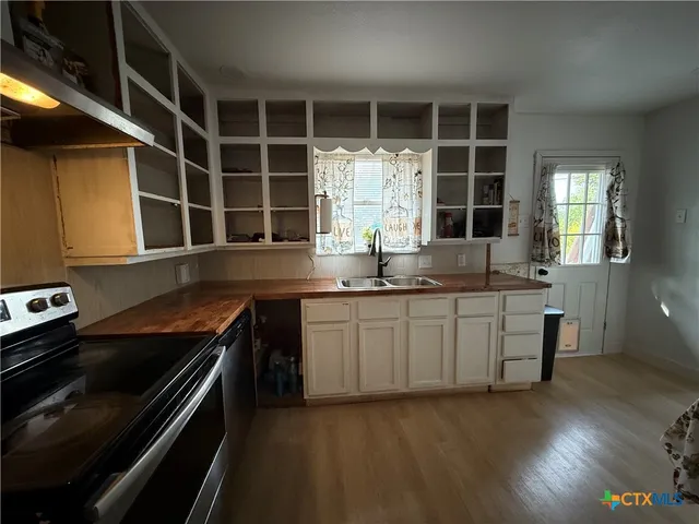a kitchen with granite countertop a sink and a stove