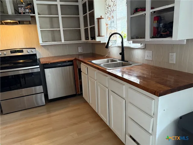 a kitchen with granite countertop a stove and a sink with wooden floor