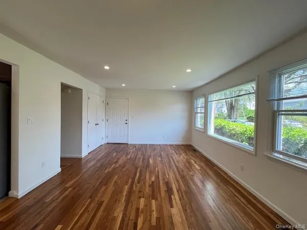 a view of wooden floor in an empty room with a window