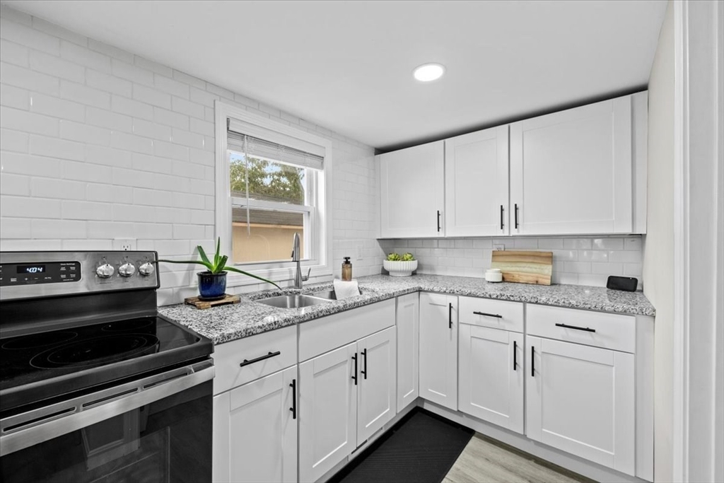 14 Pinehurst Drive Wareham, MA 02571 - Photo 15 of 41 a kitchen with granite countertop white cabinets and stainless steel appliances