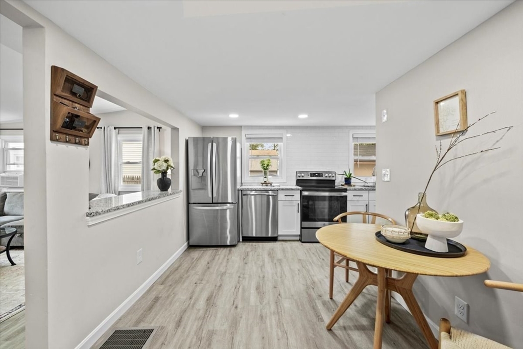 14 Pinehurst Drive Wareham, MA 02571 - Photo 19 of 41 a kitchen with stainless steel appliances kitchen island granite countertop a refrigerator a stove top oven a sink dishwasher and white cabinets with wooden floor