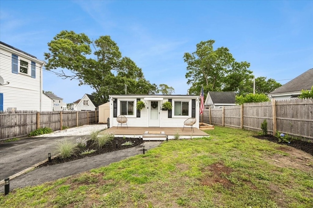 14 Pinehurst Drive Wareham, MA 02571 - Photo 28 of 41 a white house with a small yard and large trees with wooden fence