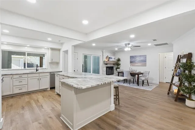 a large white kitchen with lots of counter top space and stainless steel appliances