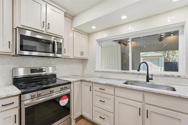a kitchen with cabinets stainless steel appliances and a sink