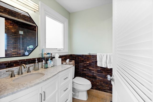 a bathroom with a granite countertop toilet sink and mirror