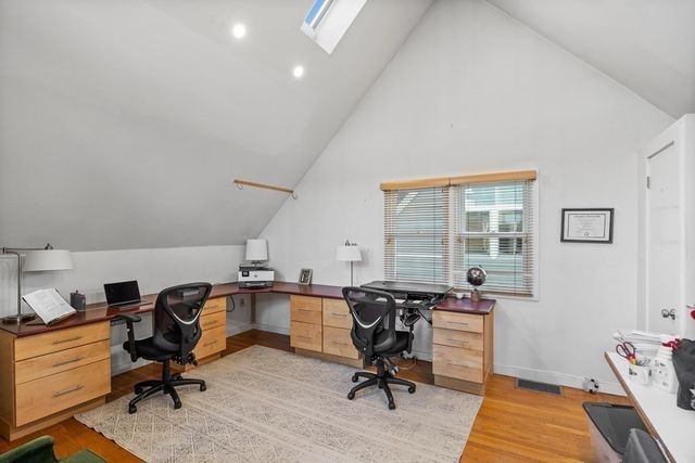 a view of a workspace with furniture and a window