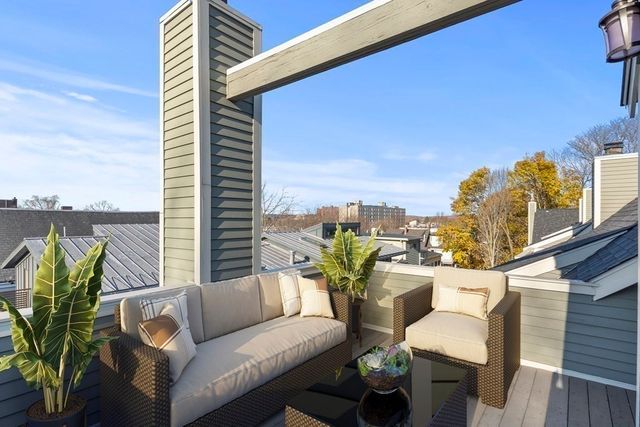 a roof deck with couches and potted plants with sky view
