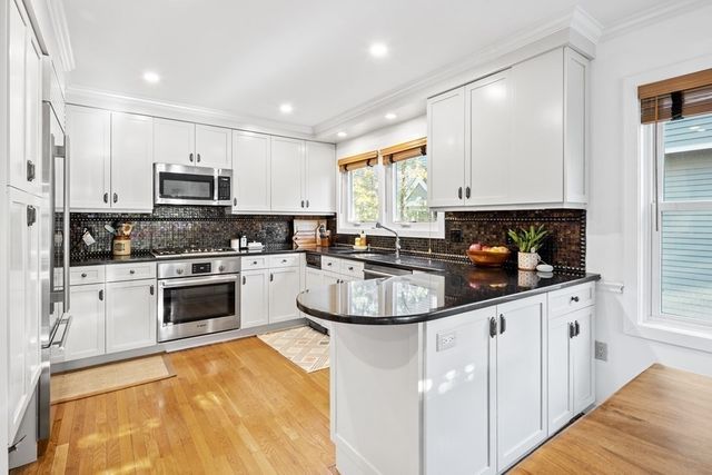 a kitchen with granite countertop a sink a counter top space appliances and cabinets