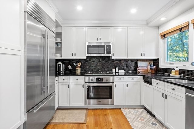 a kitchen with stainless steel appliances granite countertop a stove a sink and a refrigerator