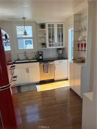 a kitchen with granite countertop a sink cabinets and stainless steel appliances
