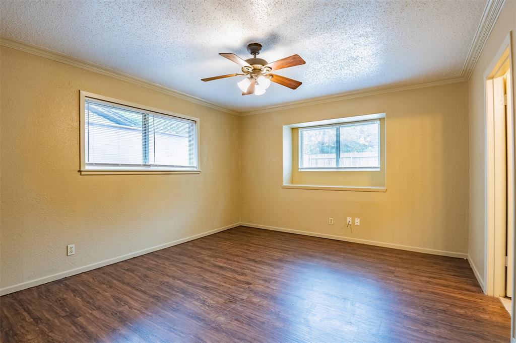 805 North Fielder Road Arlington, TX 76012 - Photo 14 of 17 a view of an empty room with wooden floor and a window
