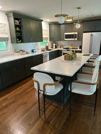 a kitchen with kitchen island a dining table and chairs