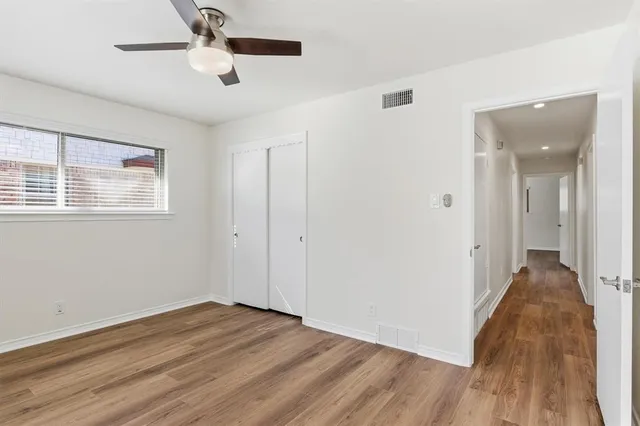 a view of a big room with wooden floor and windows