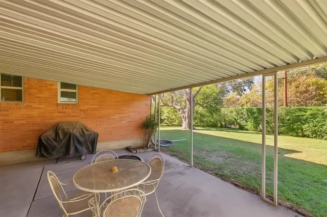 a backyard of a house with table and chairs