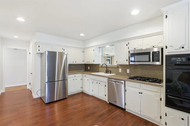 a kitchen with stainless steel appliances granite countertop a refrigerator and a stove top oven
