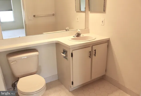 a bathroom with a sink mirror vanity and toilet