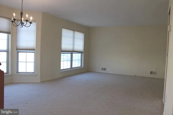 an empty room with windows and chandelier