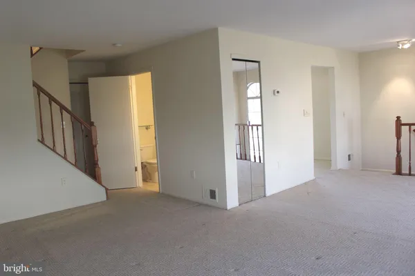 a view of an empty room with wooden floor and windows