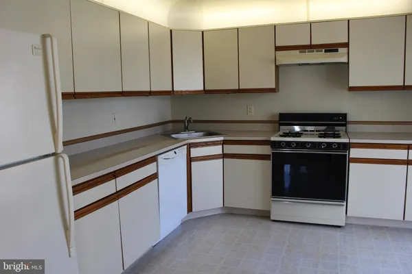 a kitchen with granite countertop white cabinets and stainless steel appliances