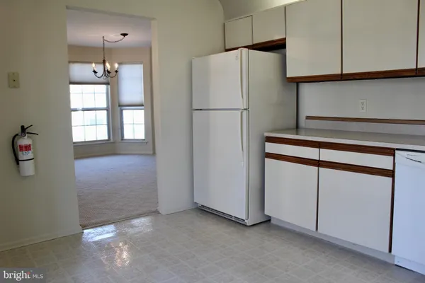 a kitchen with cabinets and a refrigerator