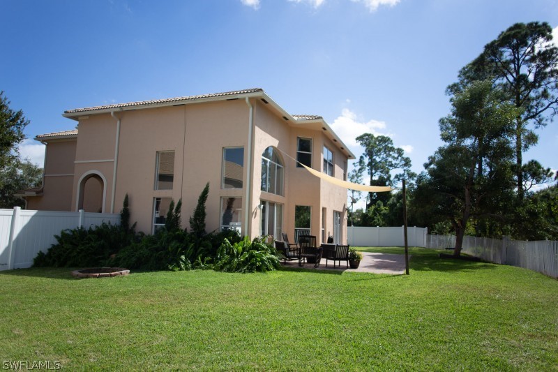 5517 Spanish River Road Fort Pierce, FL 34951 - Photo 23 of 24 a view of a white house with a big yard plants and large trees
