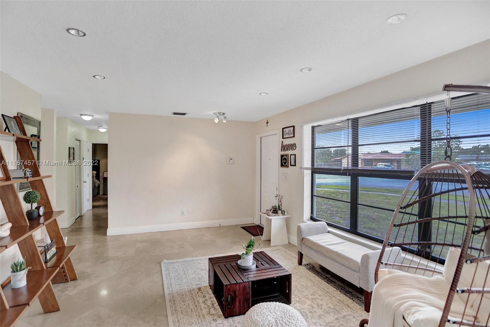 10401 Southwest 53rd Street Miami, FL 33165 - Photo 12 of 53 a living room with furniture a floor to ceiling window and a flat screen tv