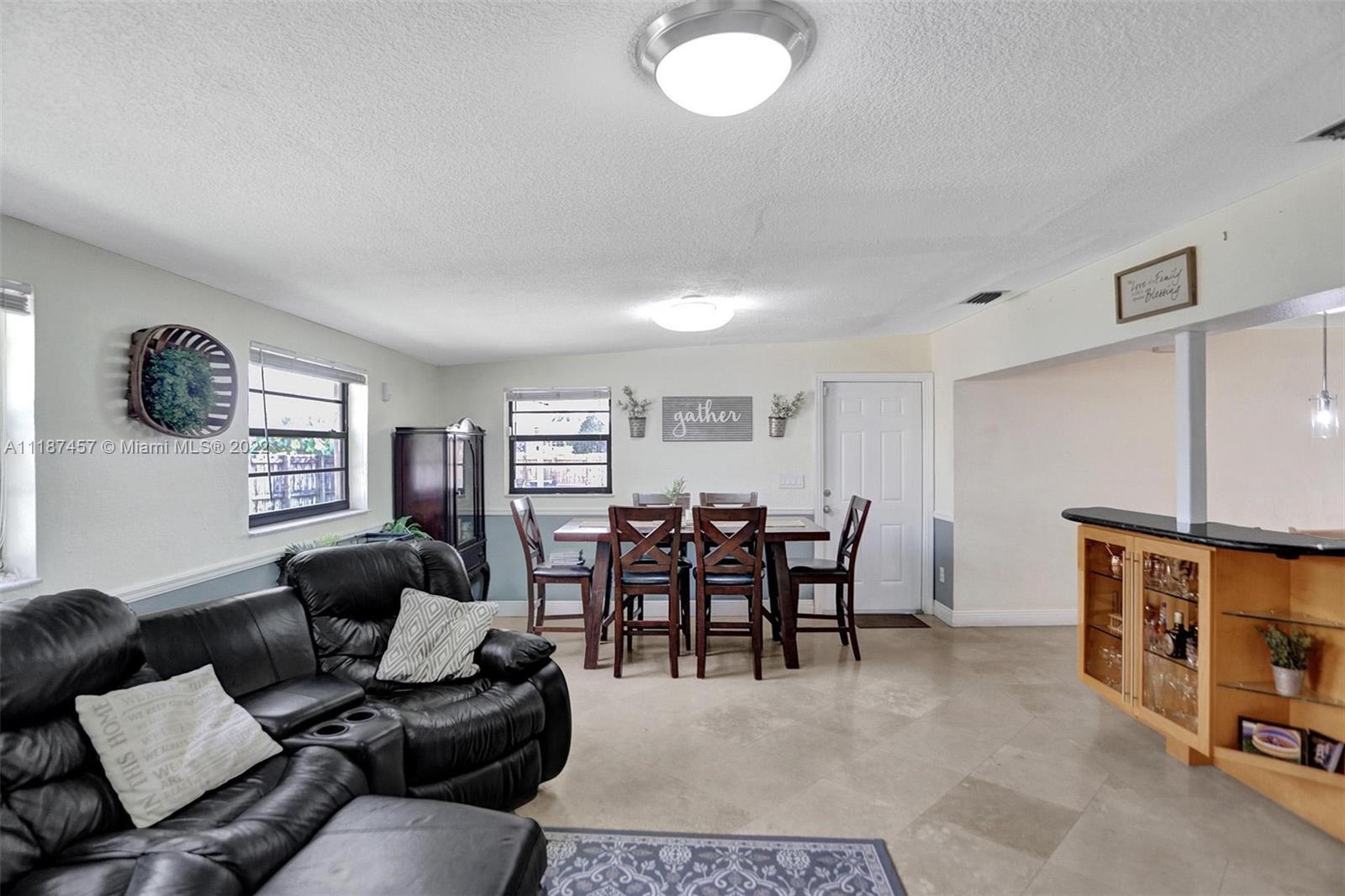 10401 Southwest 53rd Street Miami, FL 33165 - Photo 37 of 53 a living room with furniture a dining table and a bookshelf