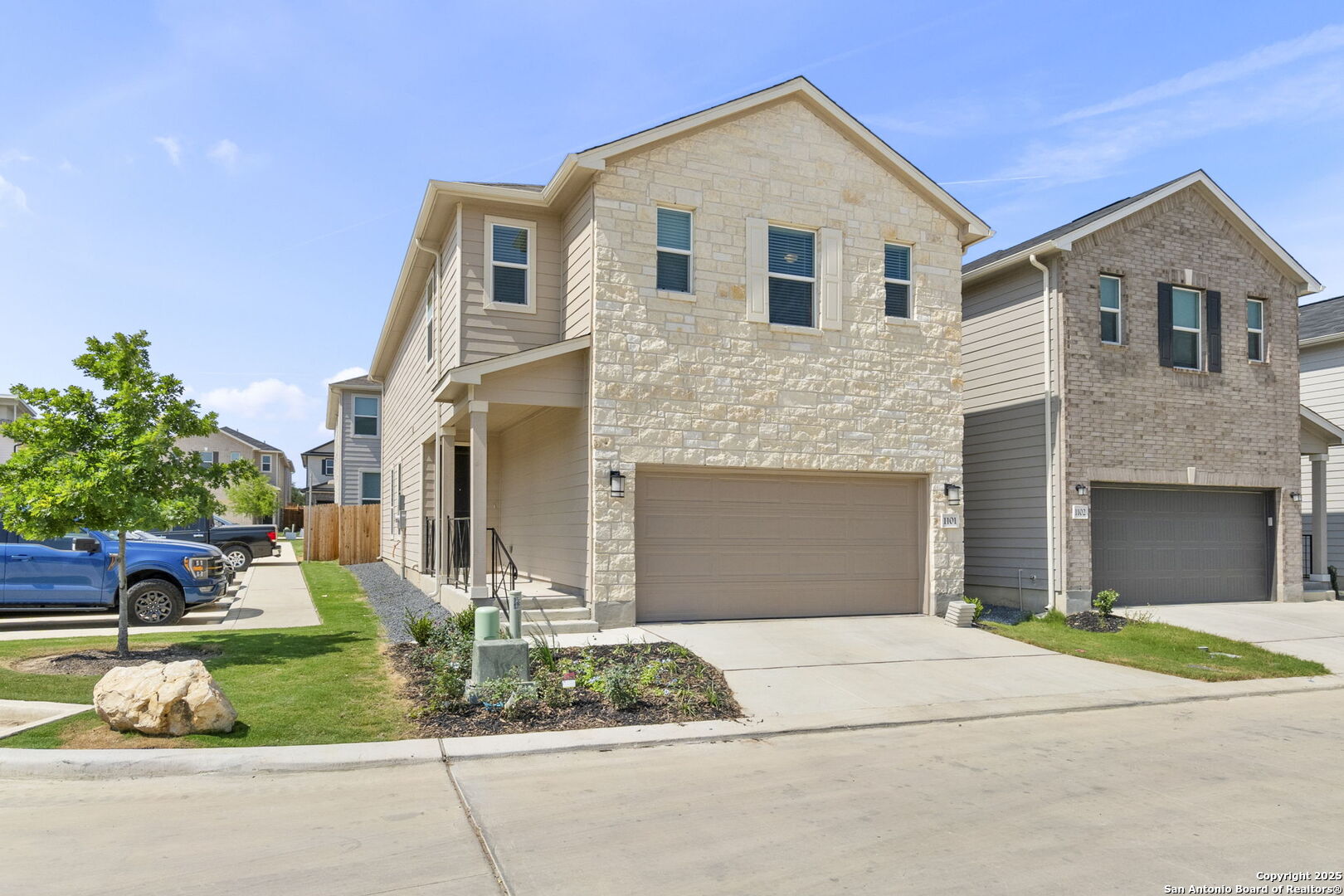 a front view of a house with a yard and potted plants