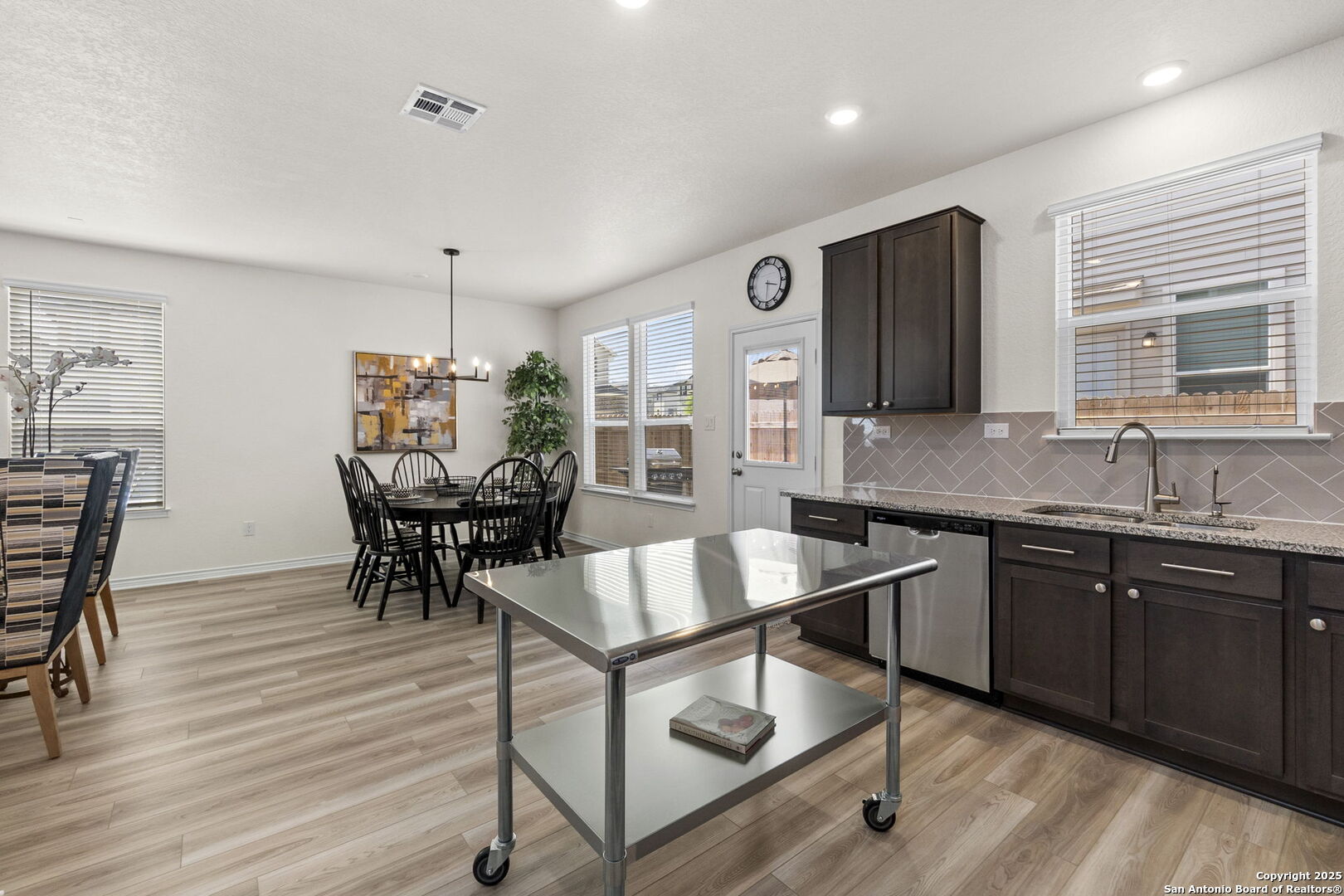 14839 Vance Jackson Road, Unit 1101 San Antonio, TX 78249 - Photo 11 of 31 a kitchen with granite countertop a stove a sink and chairs