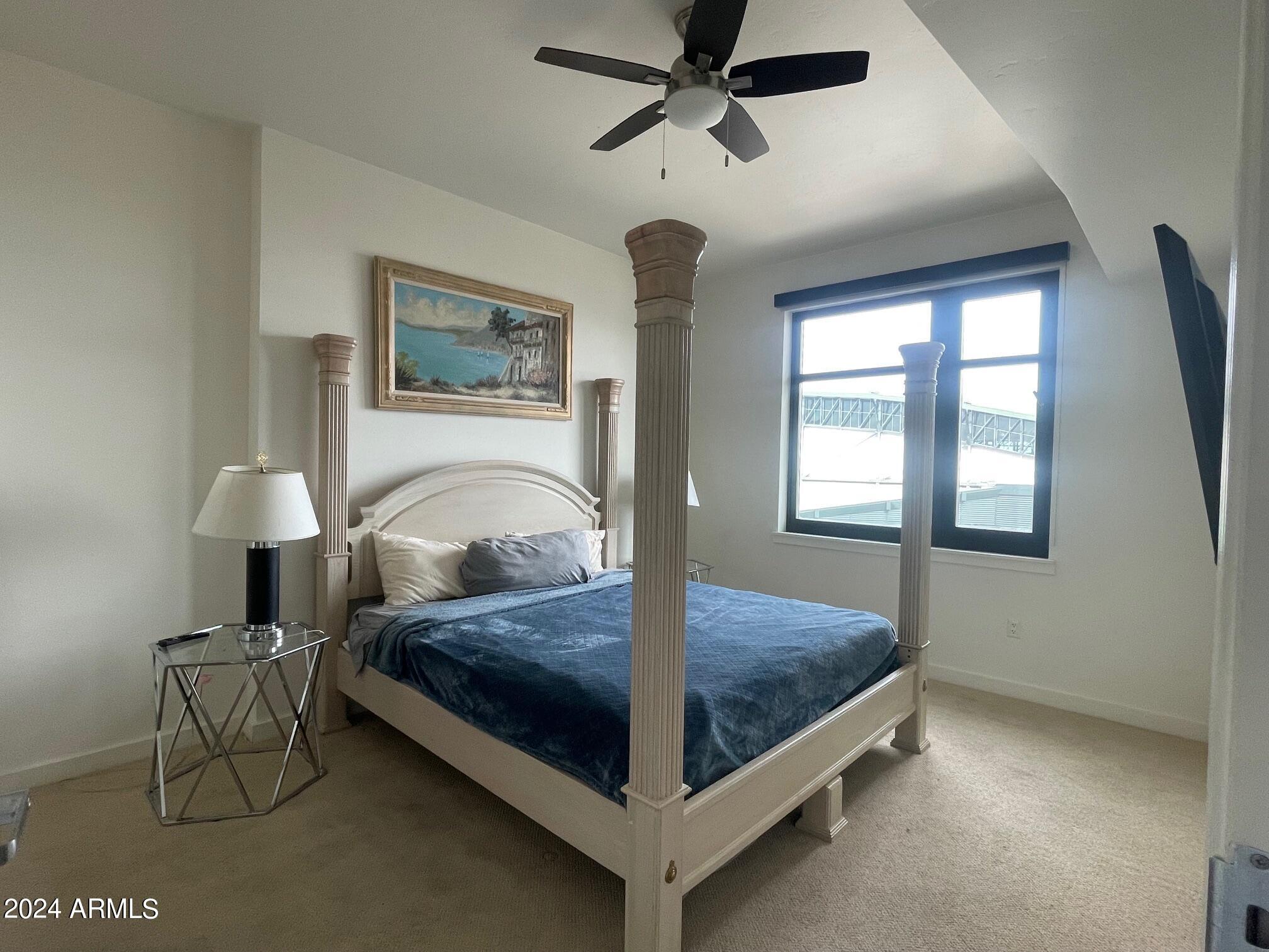 310 South 4th Street, Unit 1507 Phoenix, AZ 85004 - Photo 21 of 24 a bed sitting in a bedroom next to a window