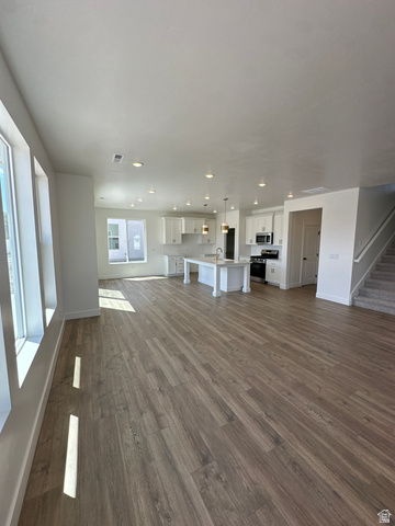 1225 West 500 South Logan, UT 84321 - Photo 16 of 39 Expansive open-concept living area featuring wood-finish flooring, a kitchen island with pendant lighting, white cabinetry, and recessed lighting throughout