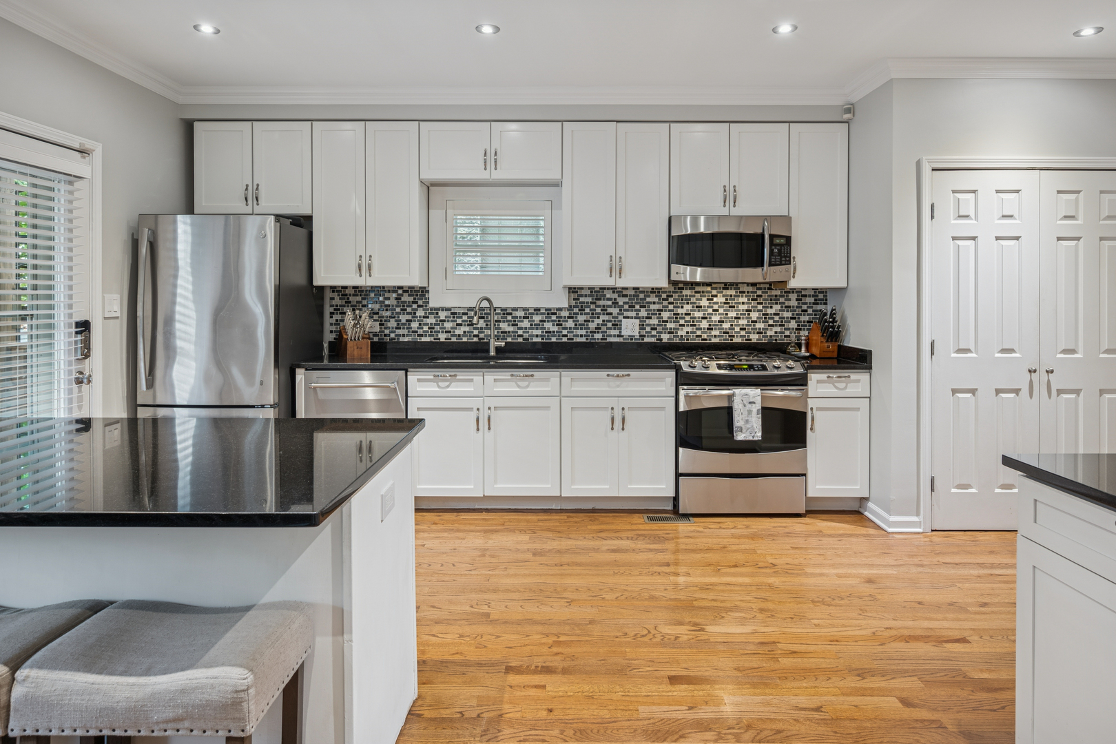 1329 North Mohawk Street, Unit 1 Chicago, IL 60610 - Photo 7 of 25 a kitchen with stainless steel appliances granite countertop a stove a sink and a refrigerator