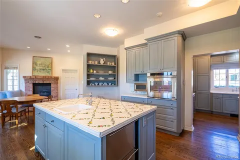 a view of a kitchen with a sink and dishwasher with wooden floor