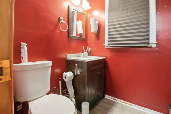 a bathroom with a toilet a sink and mirror