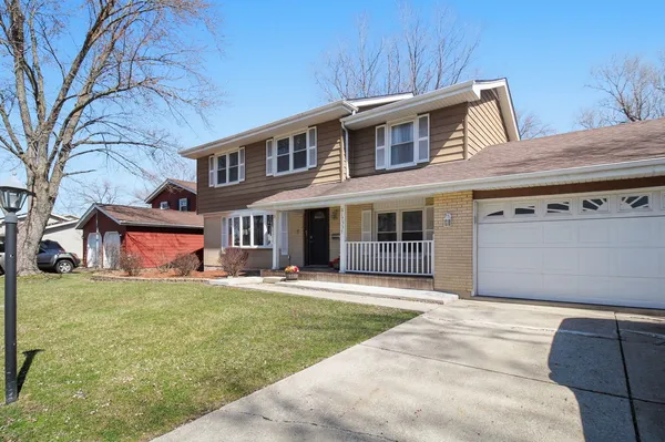 a front view of a house with a garden and yard