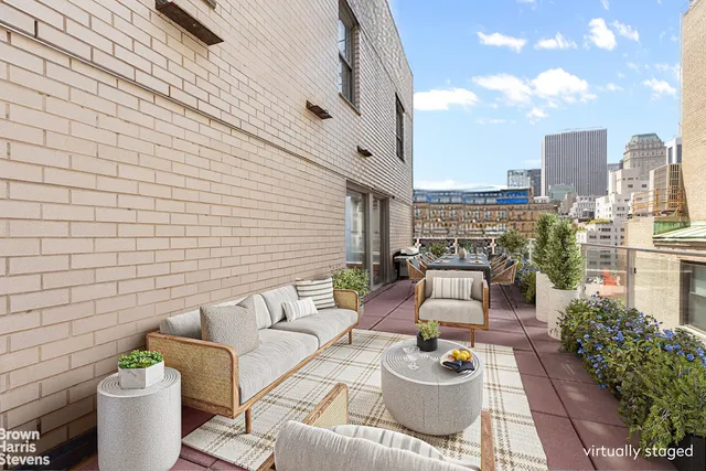 a balcony with outdoor seating and plants