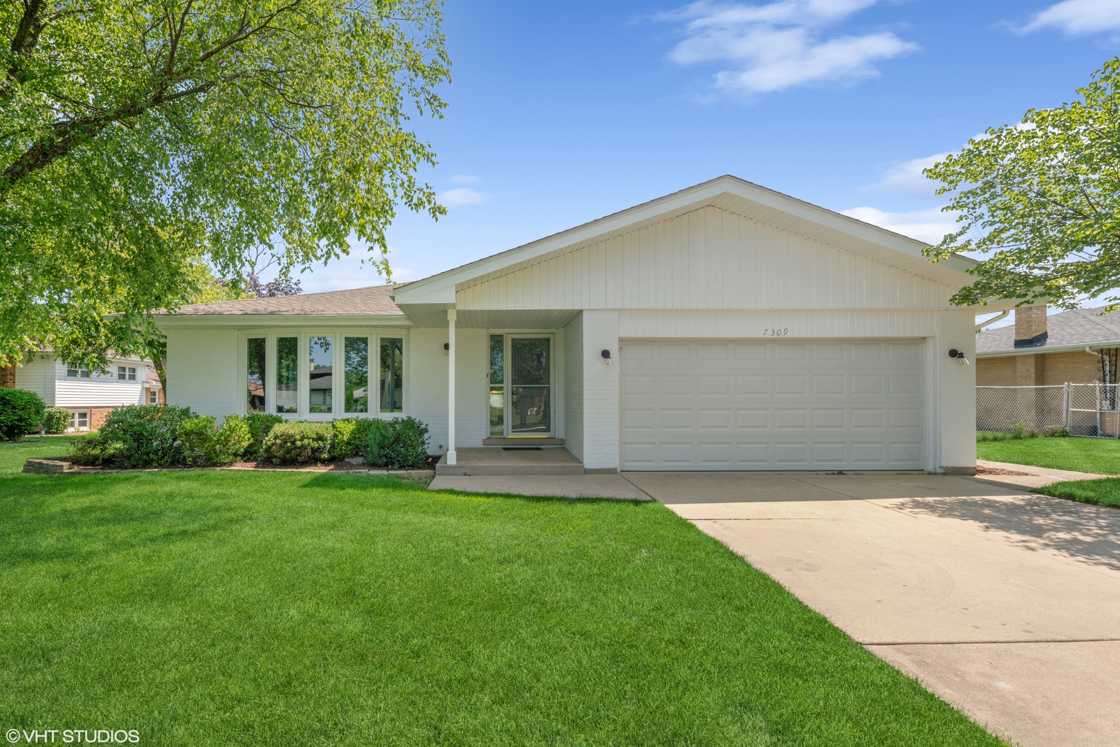 a view of a house with a yard and pathway