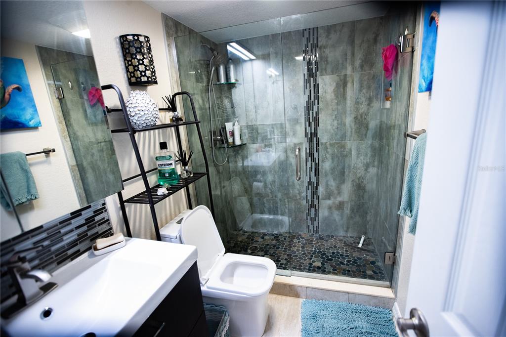 8911 Blind Pass Road, Unit 220 St. Pete Beach, FL 33706 - Photo 24 of 67 a bathroom with a sink toilet and shower