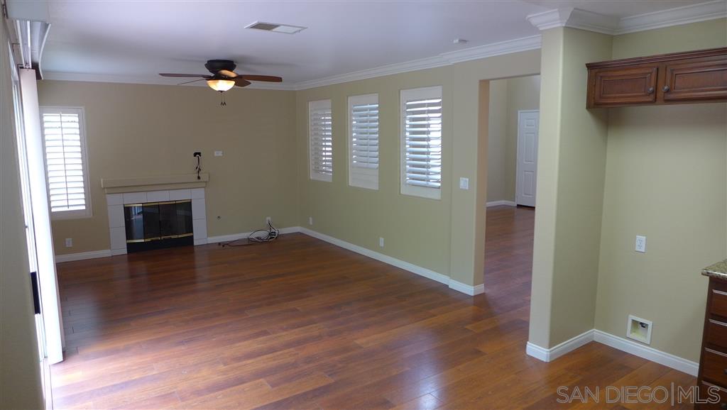 2352 Eastridge Loop Chula Vista, CA 91915 - Photo 7 of 21 an empty room with wooden floor a ceiling fan and windows
