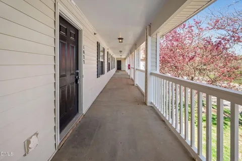 a view of a hallway with wooden floor and stairs