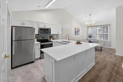 a kitchen with refrigerator and cabinets