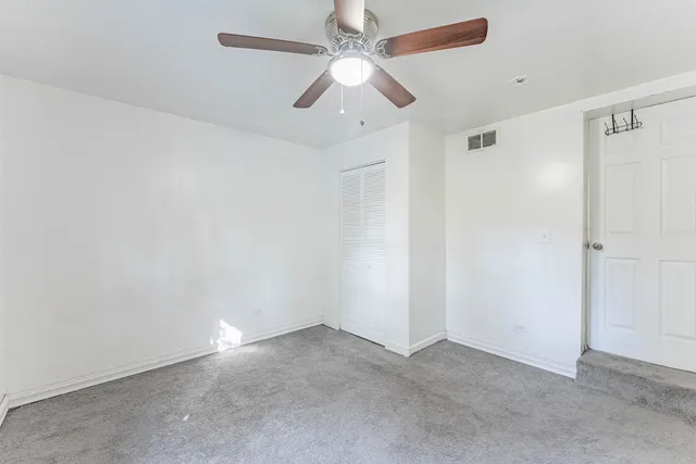 an empty room with a ceiling fan and a window