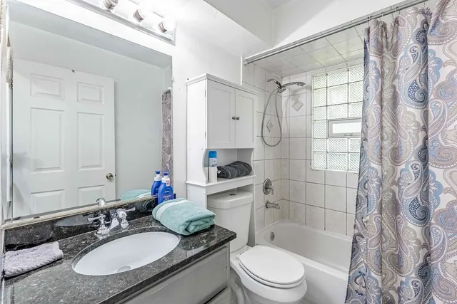 a bathroom with a granite countertop sink toilet a mirror and shower