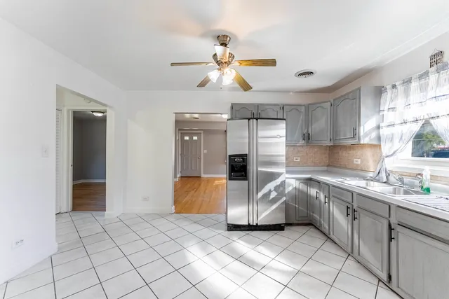 a kitchen with stainless steel appliances kitchen island granite countertop a sink and a refrigerator