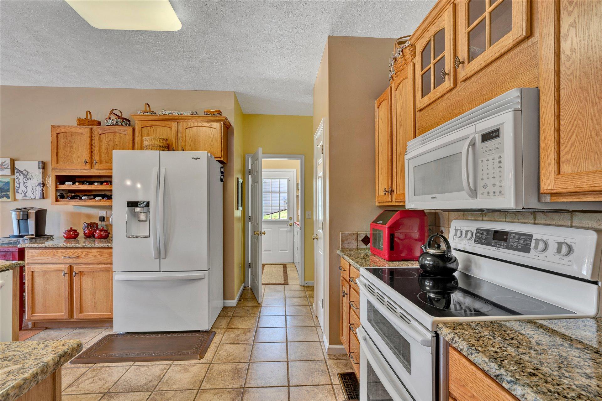 11 Cedar Bay Road Union Hall, VA 24176 - Photo 18 of 60 a kitchen with stainless steel appliances granite countertop a refrigerator a stove and a sink with wooden cabinets