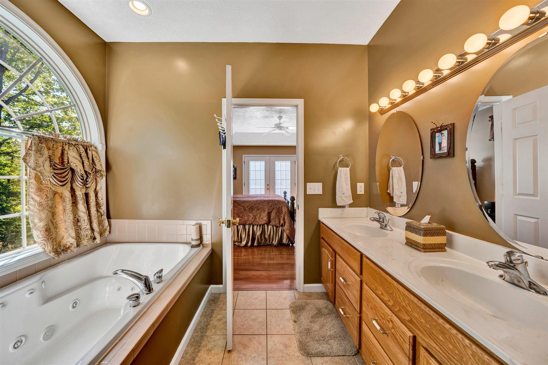 11 Cedar Bay Road Union Hall, VA 24176 - Photo 28 of 60 a spacious bathroom with a double vanity sink a mirror and a bathtub