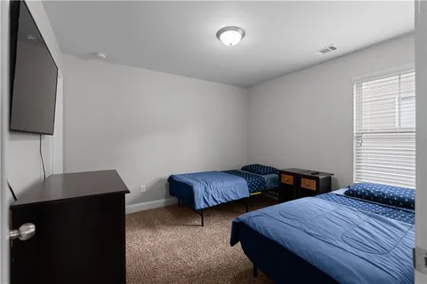 a bedroom with two beds and a flat screen tv